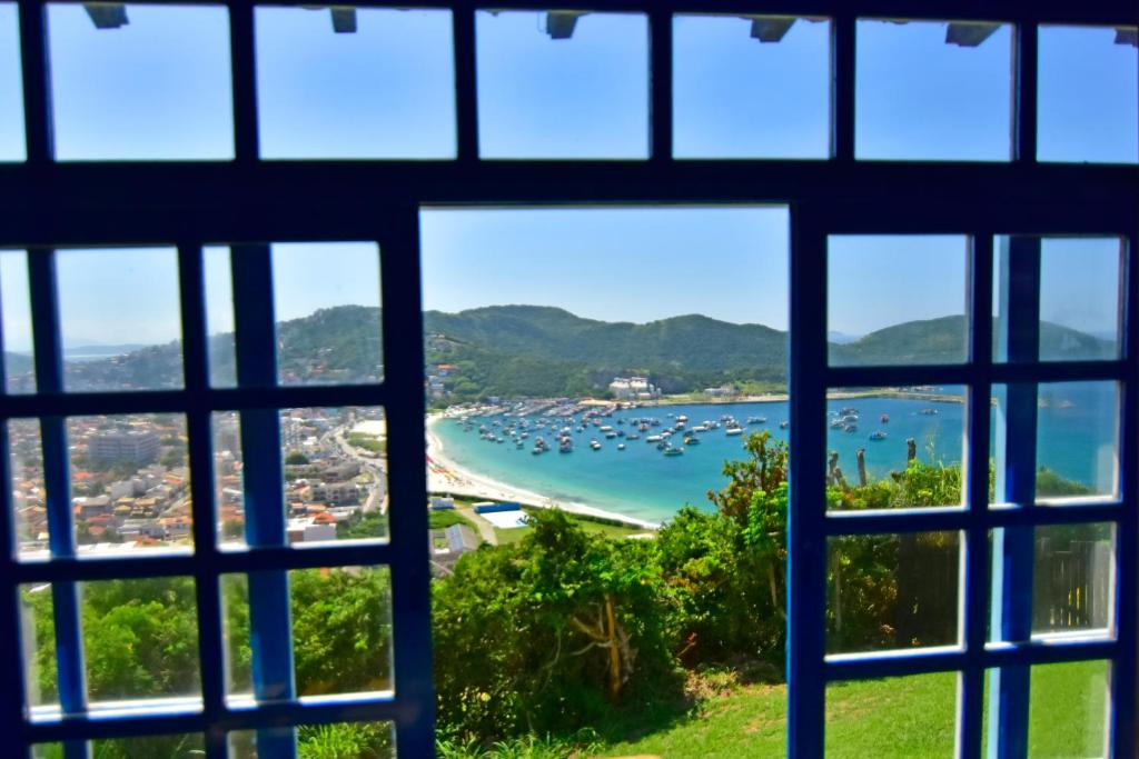 a view of a beach from a window at Pousada Tanto Mar in Arraial do Cabo