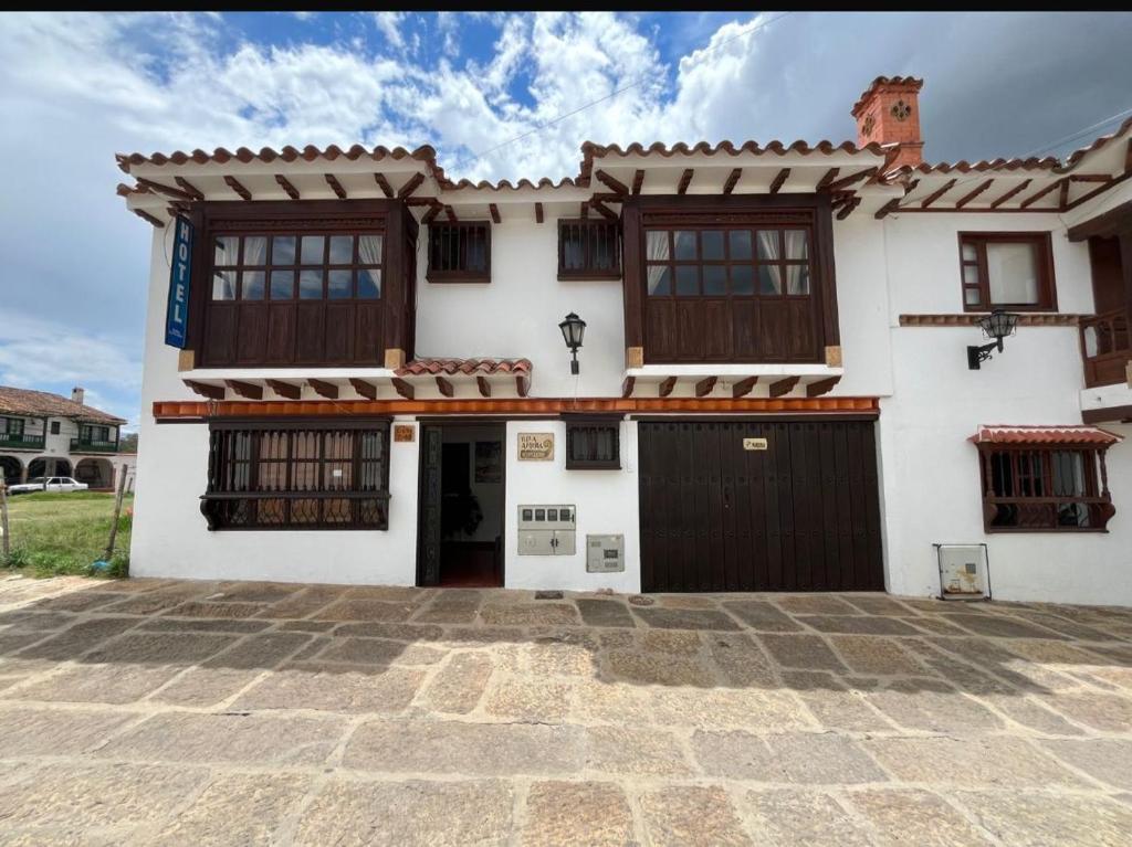 uma casa branca com janelas castanhas e uma entrada em VILLA LEWANA 2 em Villa de Leyva
