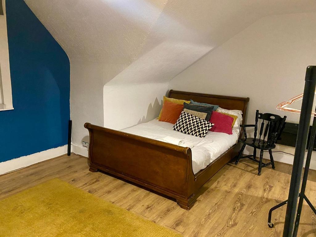 Un dormitorio con una cama con almohadas de colores. en Thornton Heath Studios - Sleeps 2, en Thornton Heath