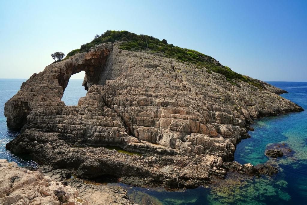 an island with an arch in the water at Villa Roxa Montuoso in Agios Leon