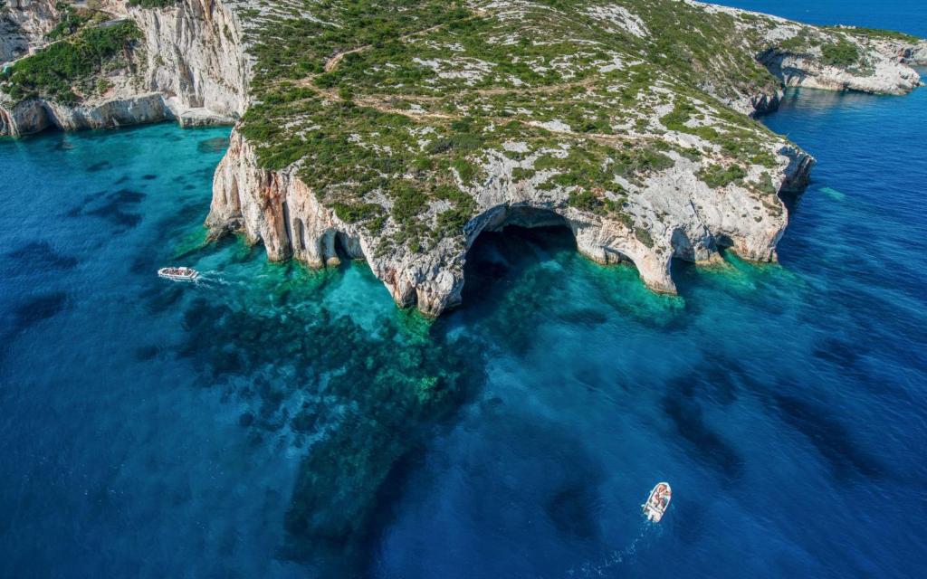 an island in the ocean with two boats in the water at Villa Roxa Montuoso in Agios Leon