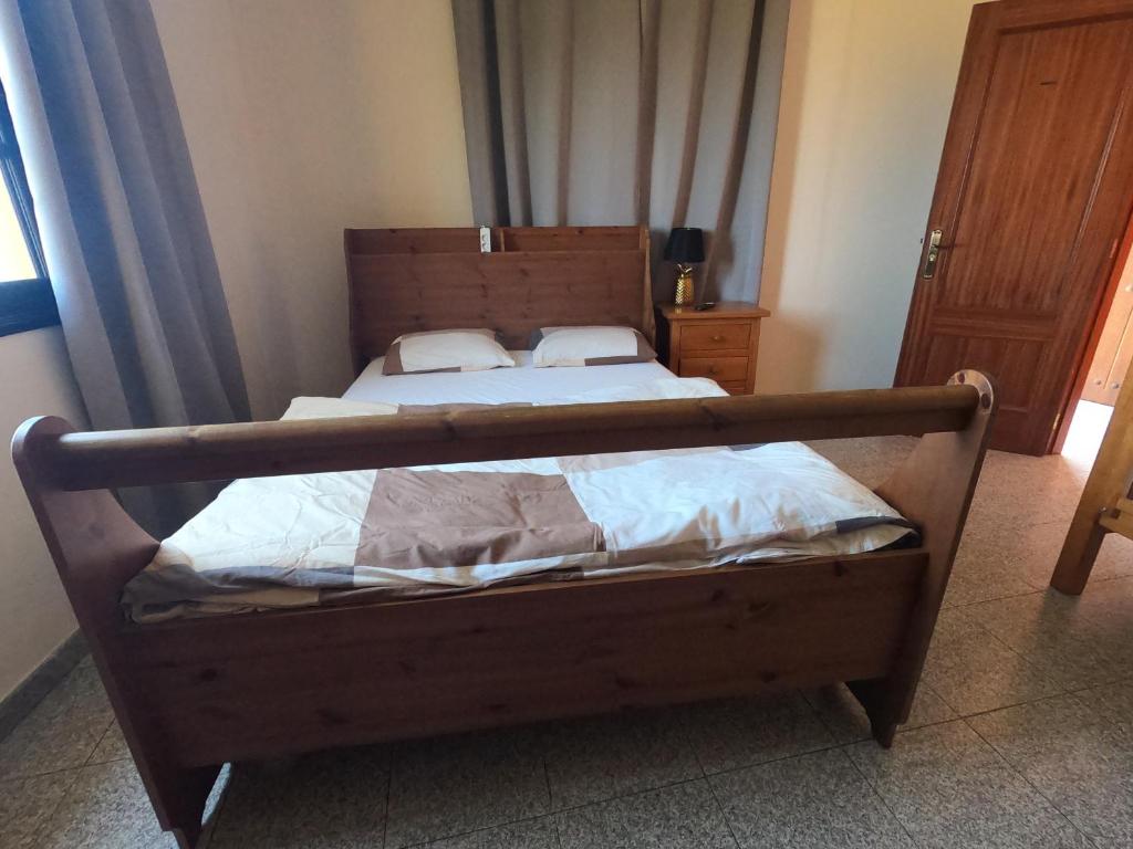 1 dormitorio con 1 cama con marco de madera en Big Room at Villa Lila, en Puerto de la Cruz