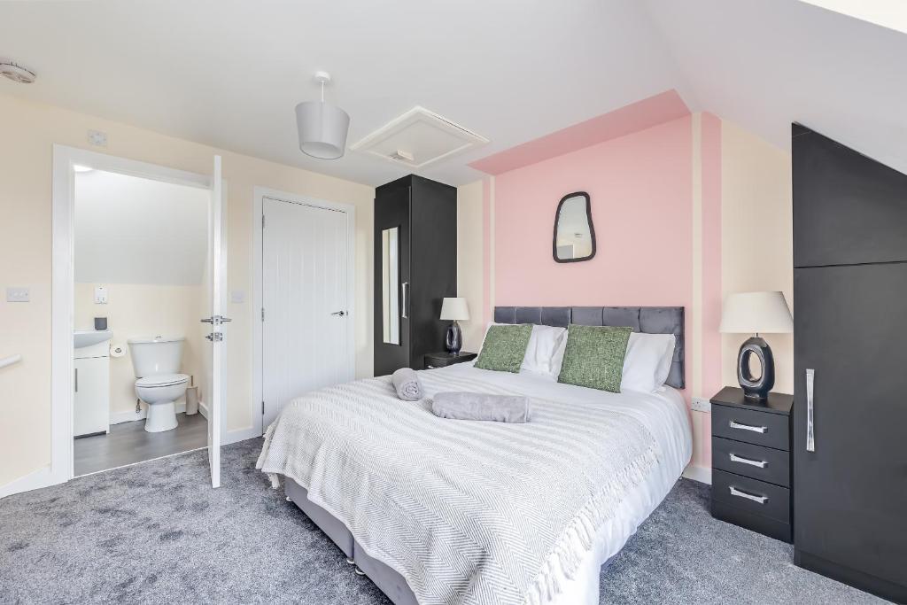 um quarto com uma cama grande e uma casa de banho em 3 Bed House - Contractors, Relocators & Visitors, Coffee Machine & Free Parking em Bedford