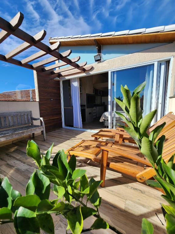 a wooden deck with a bench on a house at Casamar Lofts, Praia dos Anjos Arraial do Cabo in Arraial do Cabo
