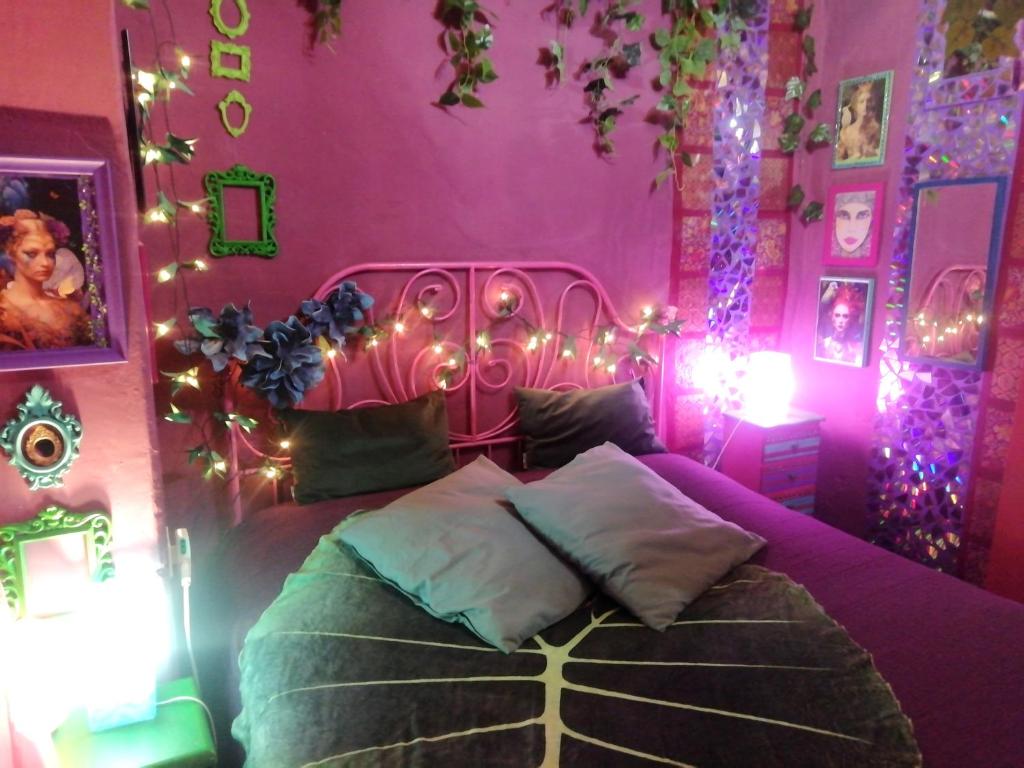 a bedroom with a pink bed with christmas lights at MAISONETTE Fata Bislacca, calcata in Calcata