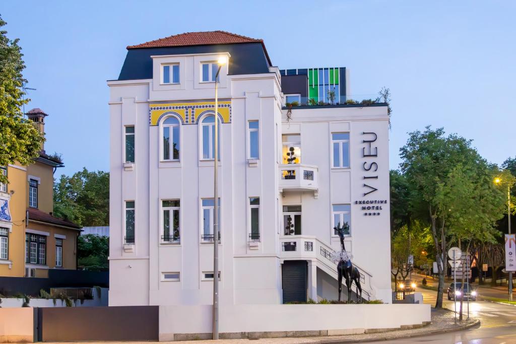 a white building on the corner of a street at VISEU EXECUTIVE Hotel in Viseu