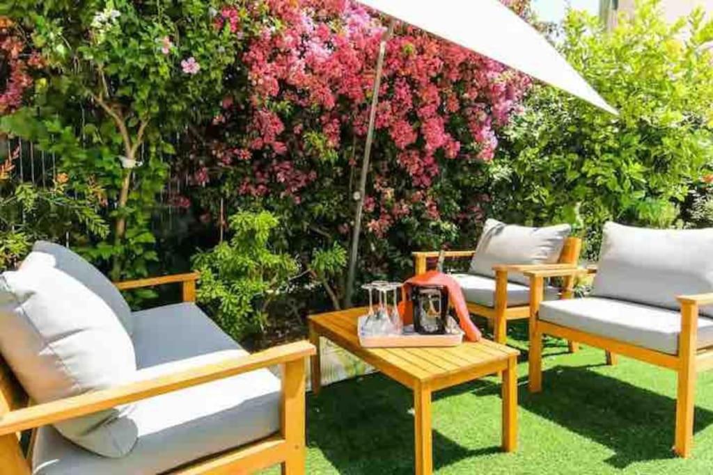 un patio con sillas y una mesa con sombrilla en Maison de ville contemporaine avec jardin en Cannes