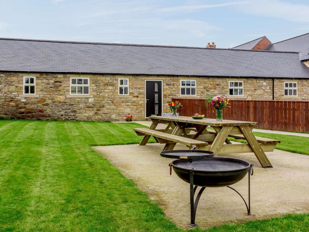 a picnic table and a grill in front of a building at 5 Bed in Bishop Auckland 83828 in Wolsingham