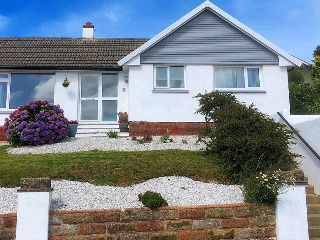 a white house with a garden in front of it at 2 Bed in Ilfracombe 82615 in Ilfracombe