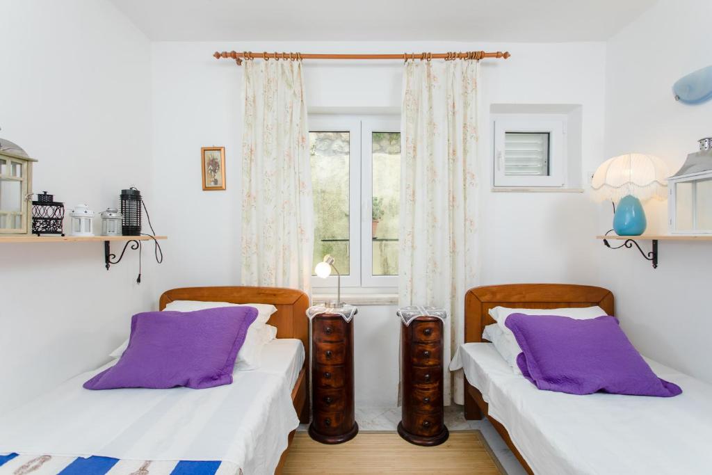 2 Betten in einem Zimmer mit lila Kissen in der Unterkunft San Giorgio apartment in Dubrovnik