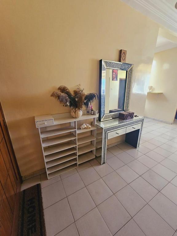 a room with a mirror on a dresser and a table with a dresser at MAISON MOUnADJA in Dakar