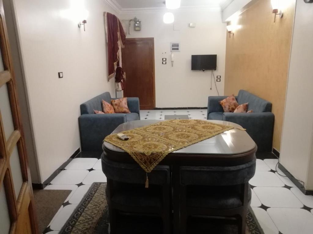 a room with a table and two chairs and a tv at Nile house in Jazīrat al ‘Awwāmīyah