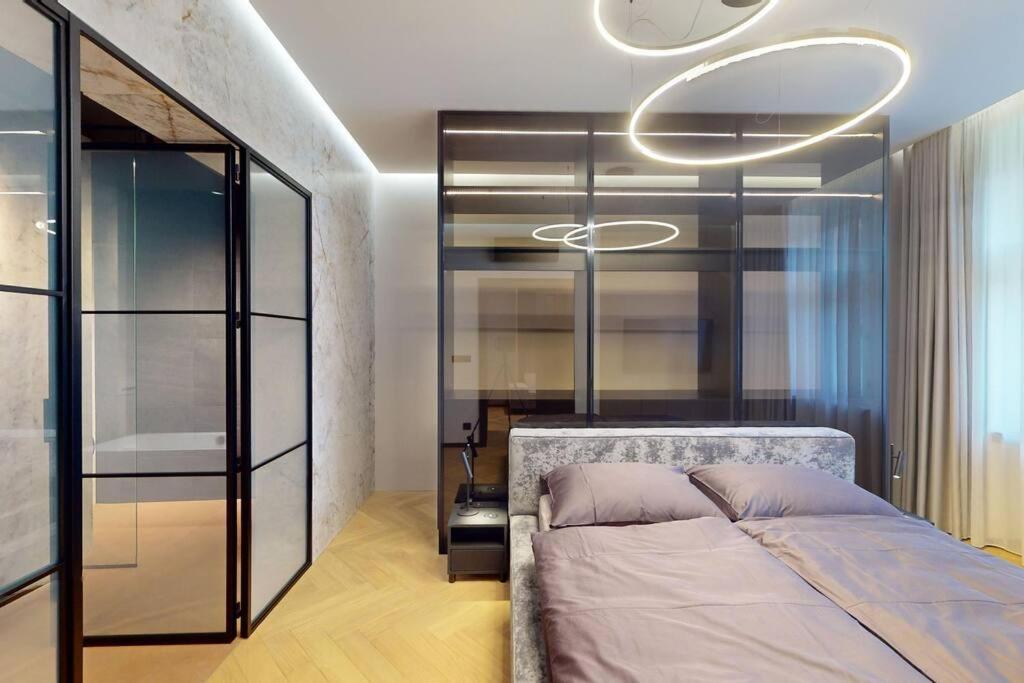 1 dormitorio con 1 cama y pared de cristal en Naprstek Urban Retreat en Praga