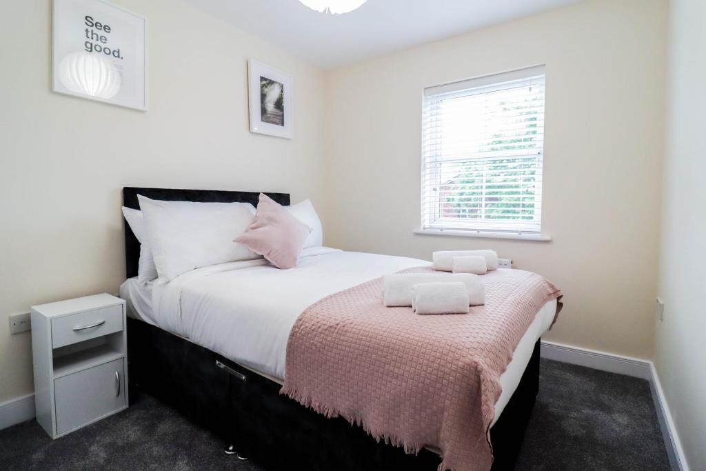 een slaapkamer met een bed met witte lakens en een raam bij 3BR House with Parking near Iron Pier Thames River in Woolwich