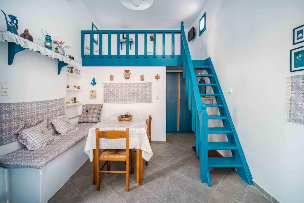 um quarto com uma mesa e uma escada azul em Alcyone em Serifos Chora