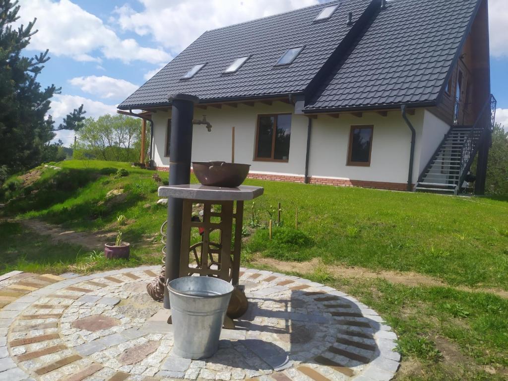 un baño de aves frente a una casa en Sosnogródek en Rutka Tartak