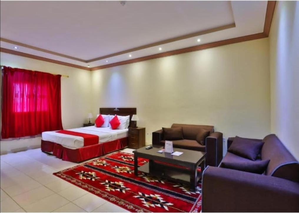 a hotel room with a bed and a couch and a table at نجمة سماء ينبع للشقق المفروشة in Madīnat Yanbu‘ aş Şinā‘īyah