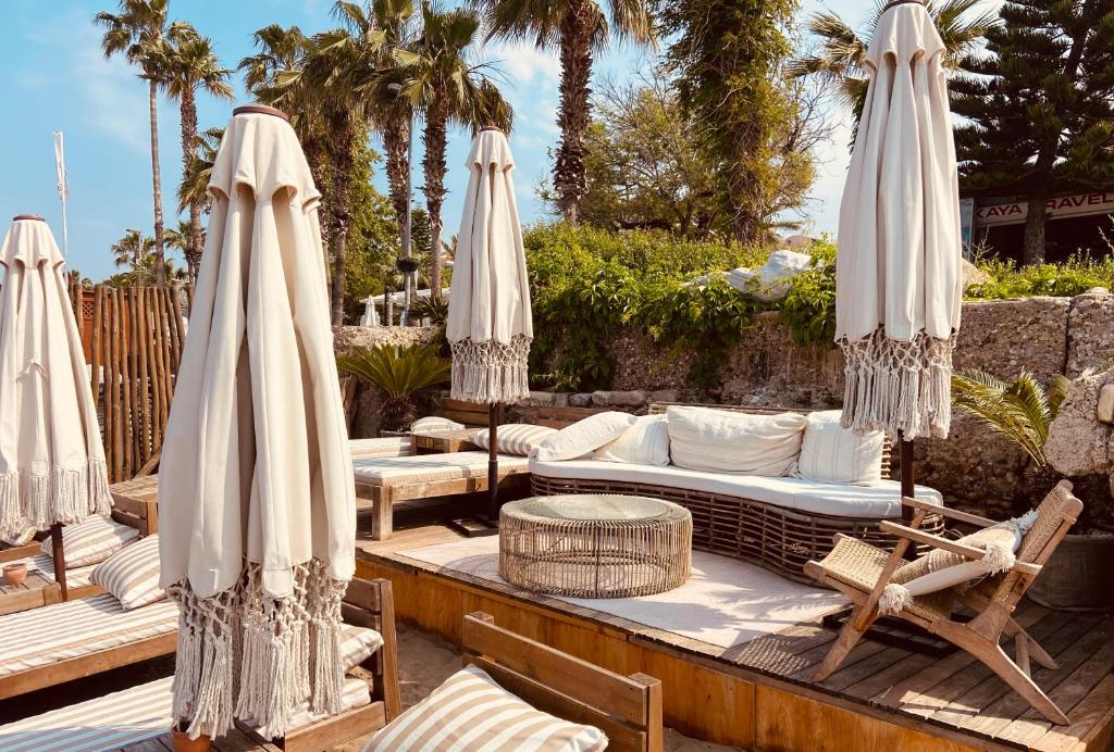 a patio with umbrellas and chaise lounges at Kalia Beach Hotel Side in Side