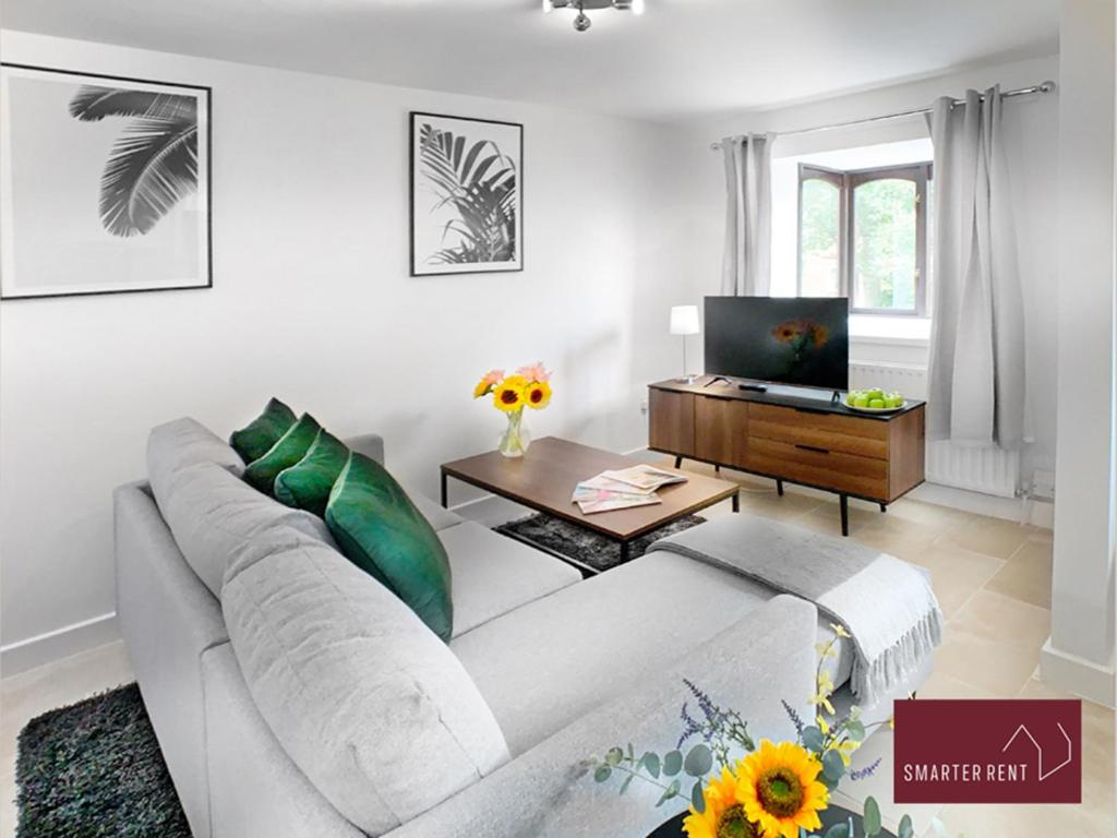 a living room with a white couch and a table at Hitchin - St Anne's - 2 bed coach house & Parking in London Colney