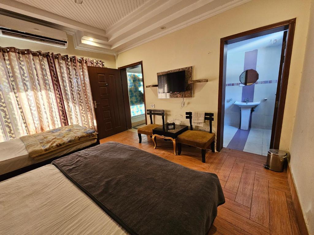 Schlafzimmer mit einem Bett und einer Glasschiebetür in der Unterkunft Hotel Versa Appartment Gulberg in Lahore