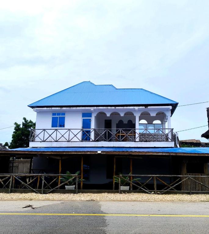 馬特姆維的住宿－PM Lodge and Restaurant，白色的建筑,蓝色的屋顶在街上