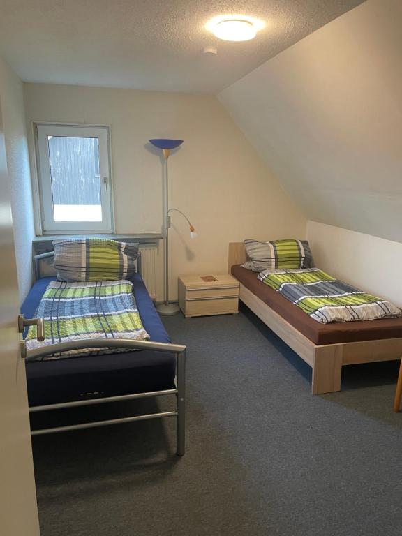 a bedroom with two beds and a window at Familie Alber 2P in Elze