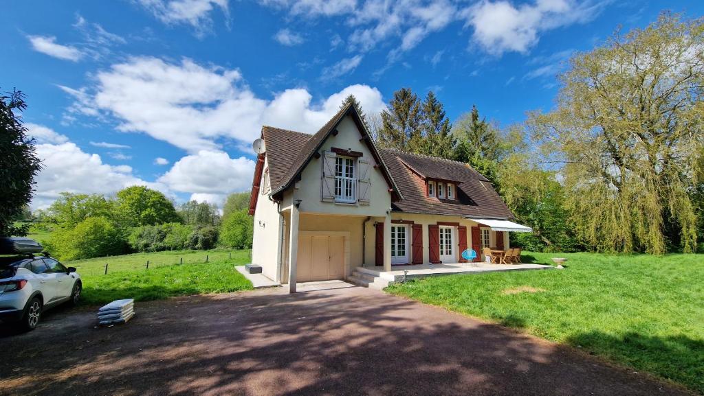 a house with a car parked in a driveway at Maison calme avec Spa et beau paysage, à 40mn des plages in Saint-Jean-de-Livet