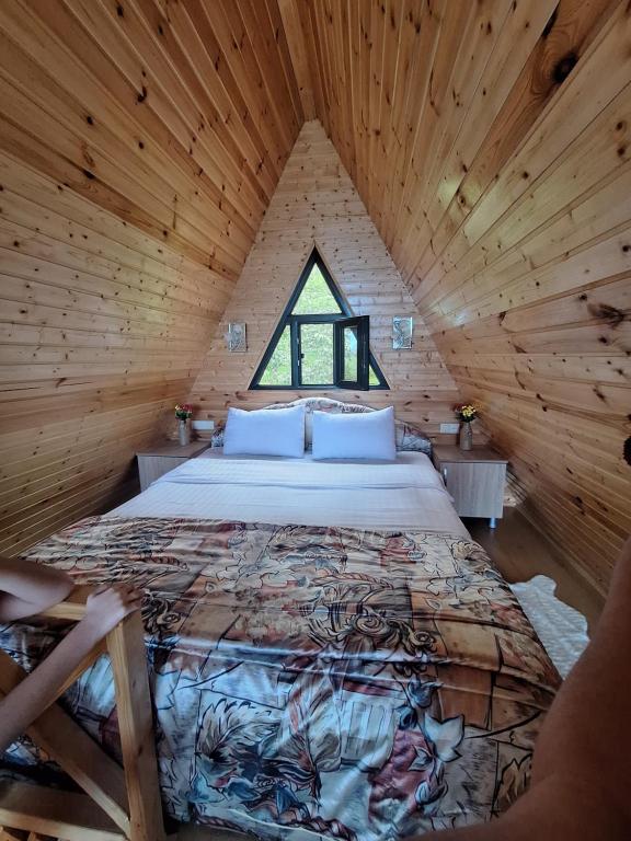 a bedroom with a bed in a wooden cabin at Eco house sunset in K'obulet'i