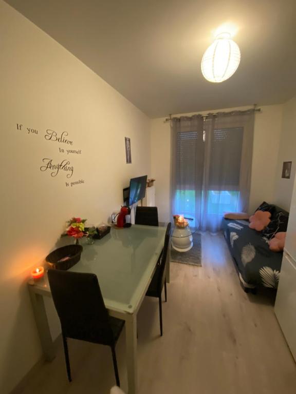 ein Wohnzimmer mit einem Tisch und einem Sofa in der Unterkunft Apparemment meublé et cosy in Gennevilliers