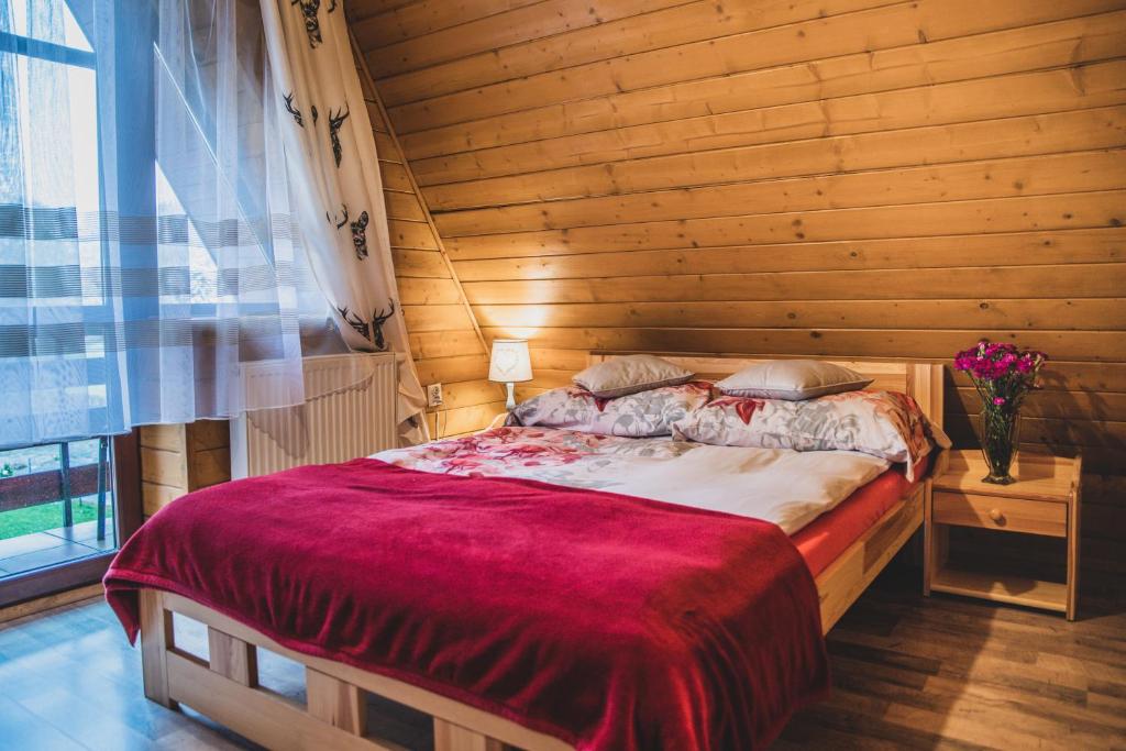 een slaapkamer met een bed met een houten muur bij Pokoje Gościnne na Stromej in Zakopane