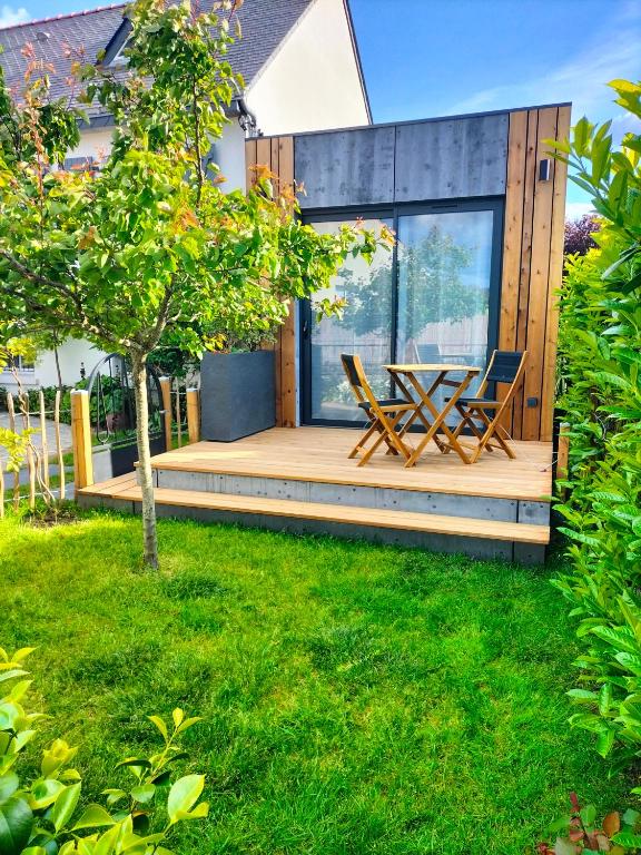 une maison avec une terrasse avec une table et des chaises dans l'établissement Studio Zen et Bois, à Écouflant
