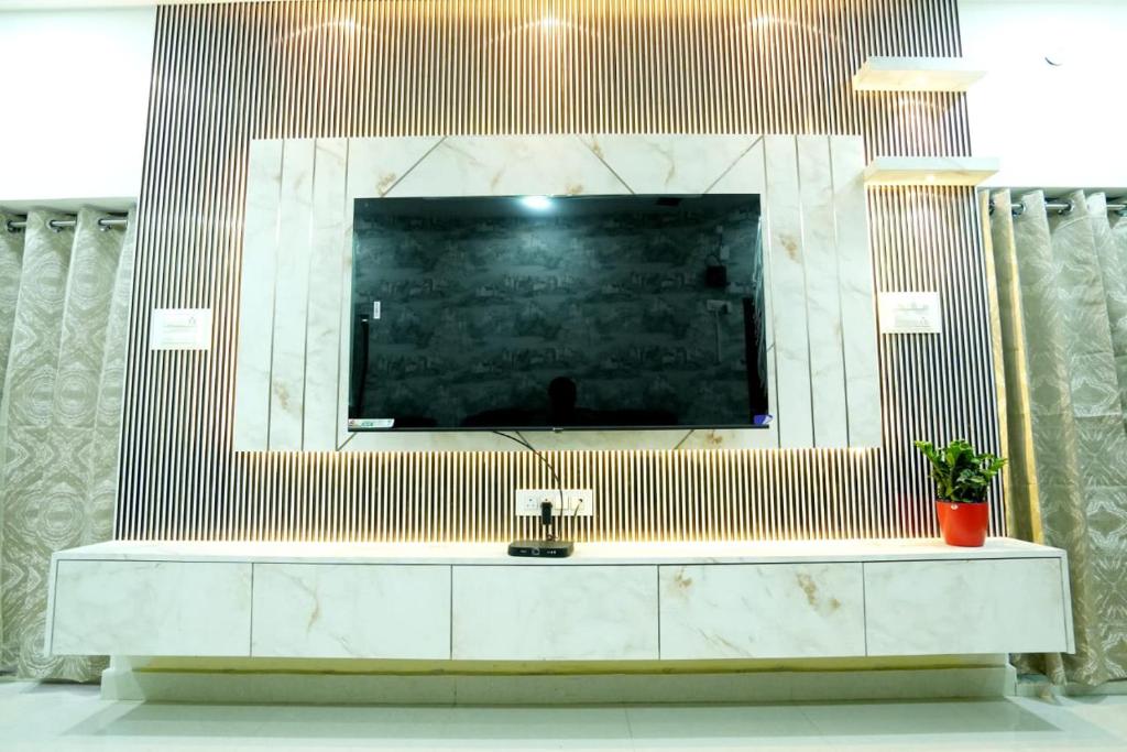 une grande télévision sur un mur dans une pièce dans l'établissement Tiram Villa, à Visakhapatnam
