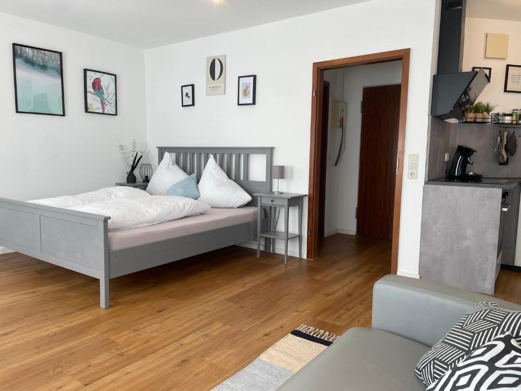 a bedroom with a bed and a living room at Studio 76 - Apartment zentrale Lage ganze Wohnung in Friedrichshafen