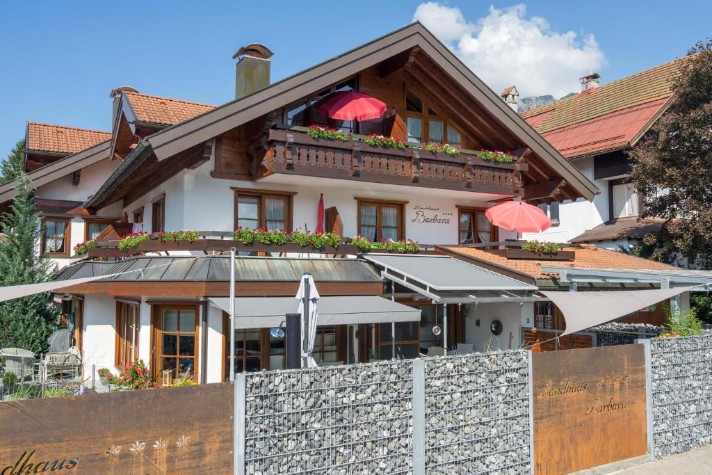 ein Gebäude mit einem Zaun davor in der Unterkunft Landhaus Barbara Ferienwohnungen in Oberstdorf
