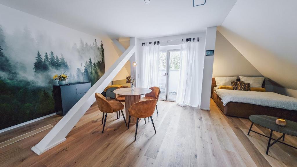 a room with a bed and a table and chairs at Suite 13 im Wald mit Balkon in Amberg
