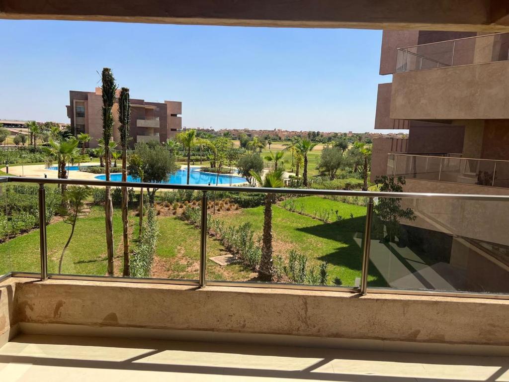 einen Balkon mit Poolblick in der Unterkunft Golf stay with Atlas view at Marrakech! in Marrakesch