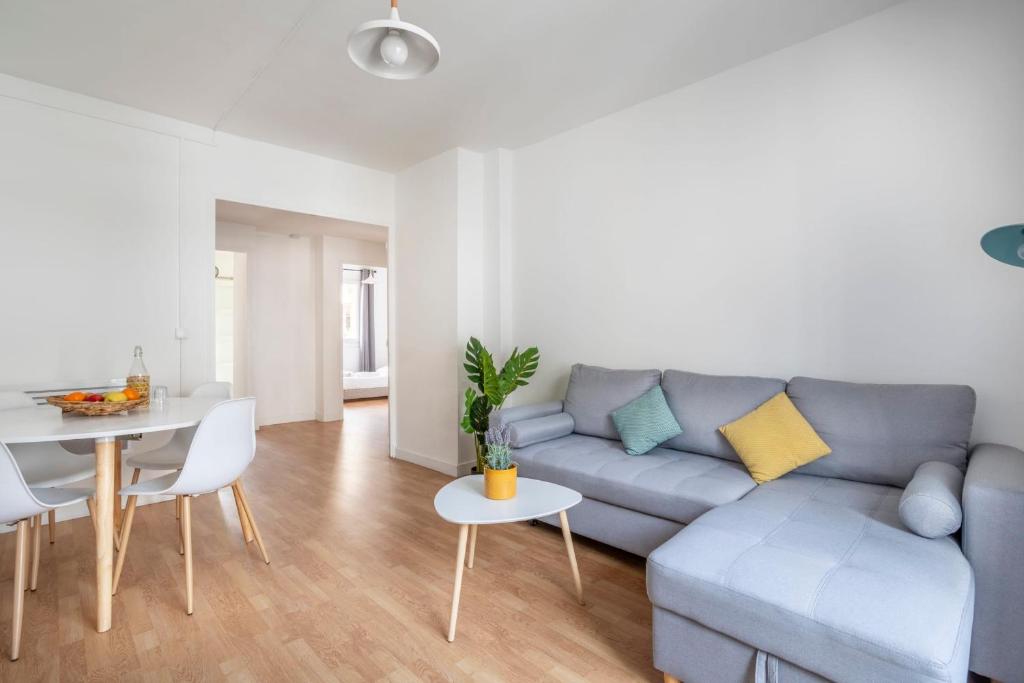 uma sala de estar com um sofá azul e uma mesa em Charming apartment in Marseille - Welkeys em Marselha