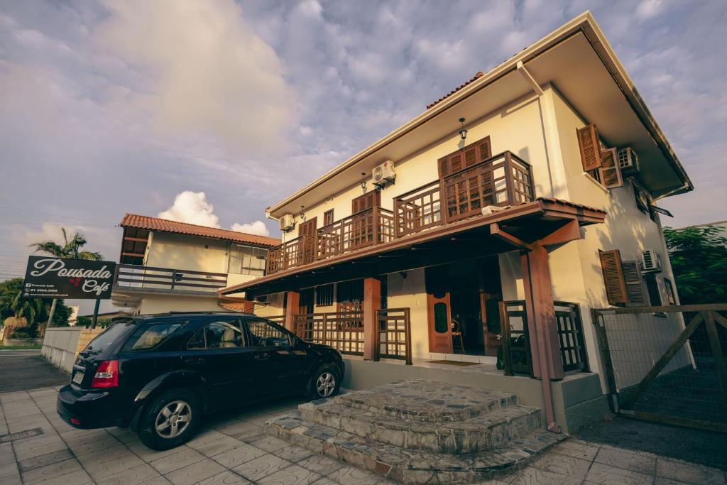 a car parked in front of a building at Pousada Café in Torres