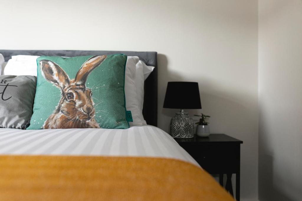 a bed with a picture of a rabbit on a pillow at Skyvillion -COZY & AMAZING King 1Bed Apartment in London Cockfosters Mins to Tube in Cockfosters