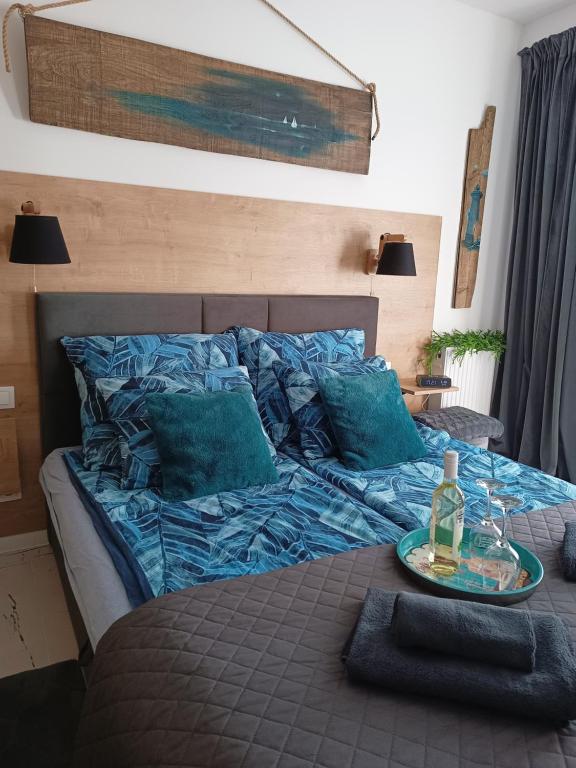 a bed with blue sheets and a table with a bottle on it at NAD LISIM JAREM 2 in Jastrzębia Góra