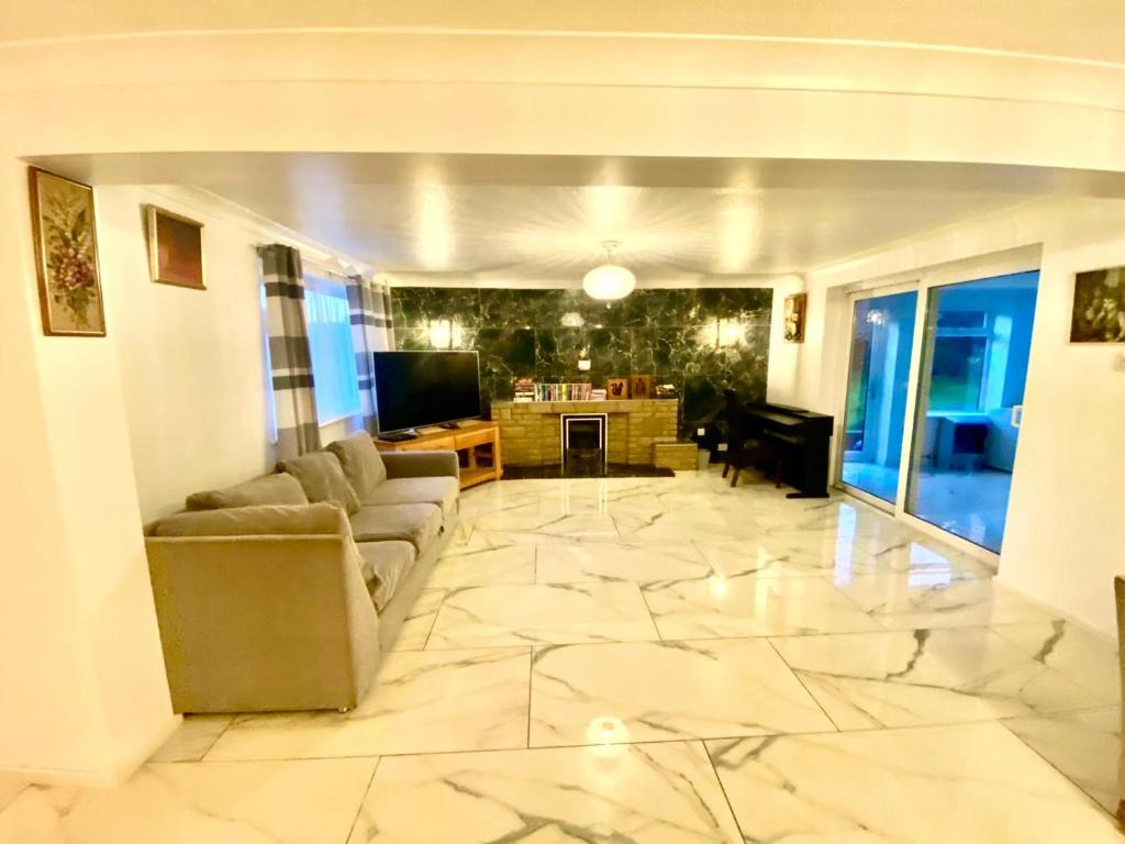 uma sala de estar com um grande piso em mármore em Luxury Large Four Bedroom Family Home Free Car Park em Luton