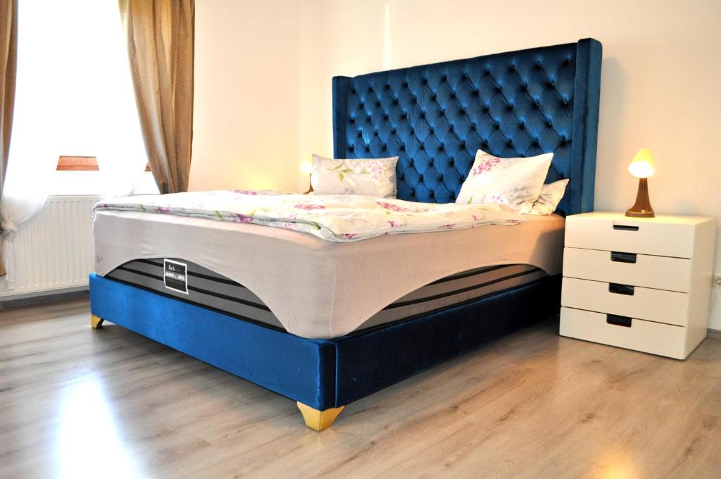 een bed met een blauw bedframe en een nachtkastje bij EG Das Familien-Apartment TOP 1 in Wenen