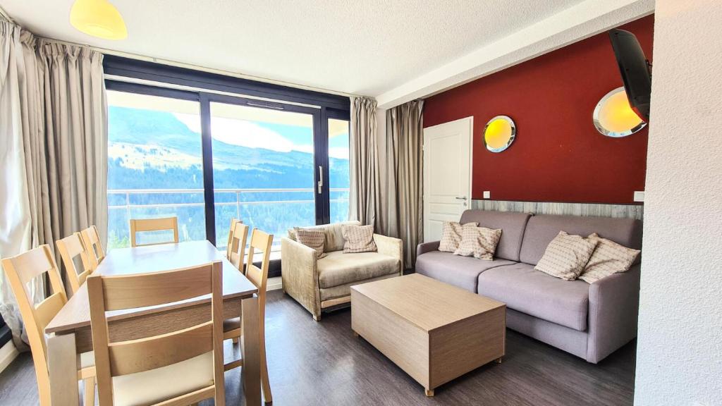 un salon avec un canapé et une table dans l'établissement Résidence Les Terrasses De Veret - Appartement lumineux · Au pied des pistes · Piscine · Parking inclus · Spa MAE-1651, à Magland