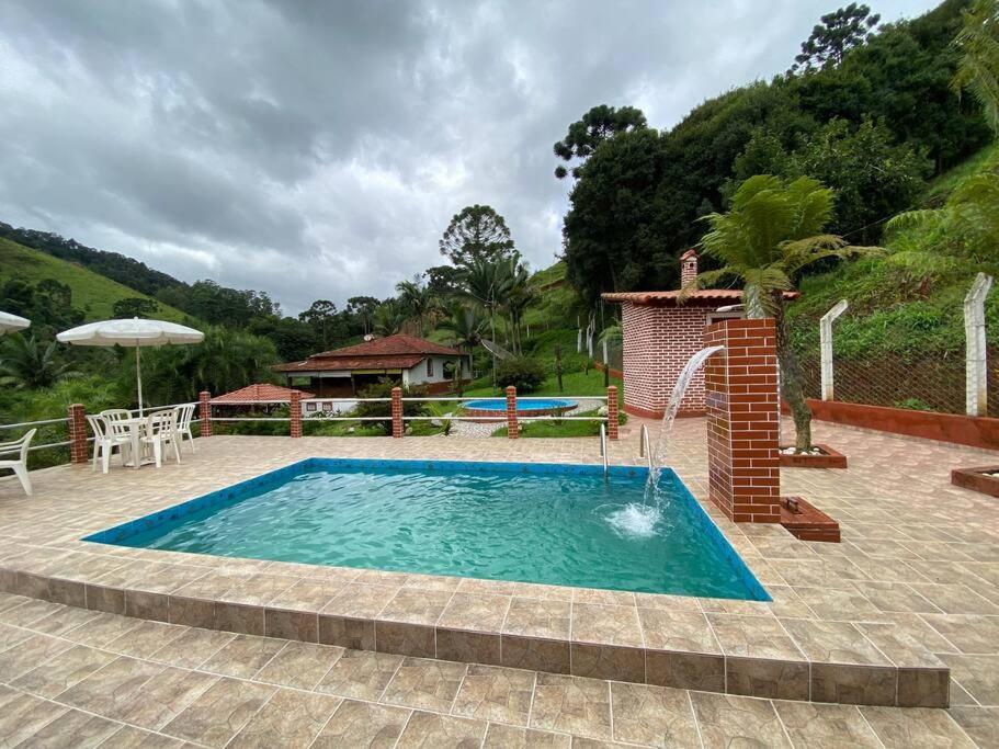 a swimming pool in the middle of a patio at Fazenda São Lourenço na Serra da Mantiqueira in Queimada