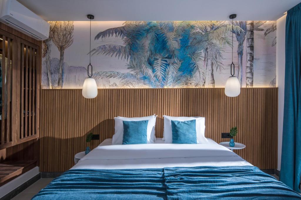 a bedroom with a large bed with blue sheets at Lotus Studios in Malia