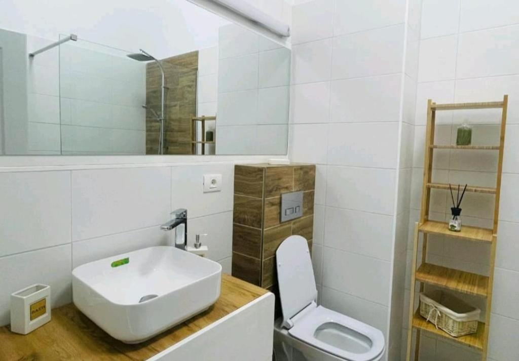 ein weißes Bad mit einem Waschbecken und einem WC in der Unterkunft Stefan Resort Mamaia Nord in Mamaia Nord – Năvodari