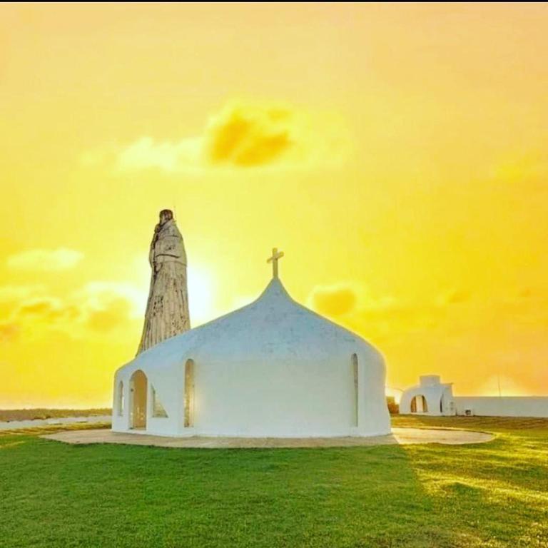 a small white church with a statue on top of it at Santuário Hotel Fazenda in Santo André