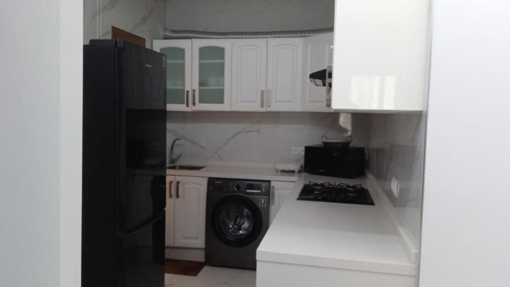 a kitchen with white cabinets and a black refrigerator at Fantástic apartment the beach marina 2 in Tetouan