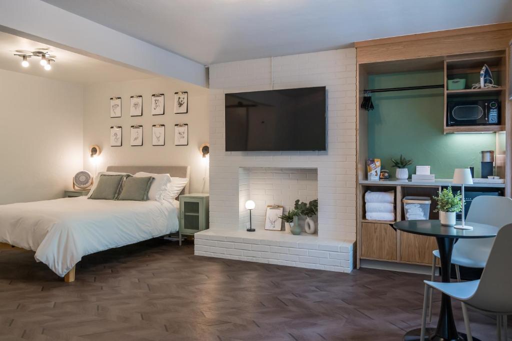 a bedroom with a bed and a tv above a fireplace at The Local Motel & Shops in Eugene