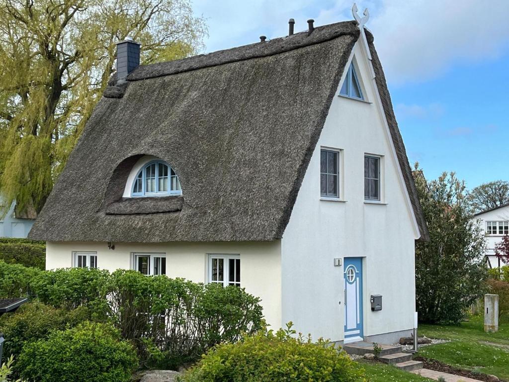 a white house with a thatched roof at Reetdachhaus mit eigenem Strandkorb in Wohlenberg an der Ostsee in Wohlenberg